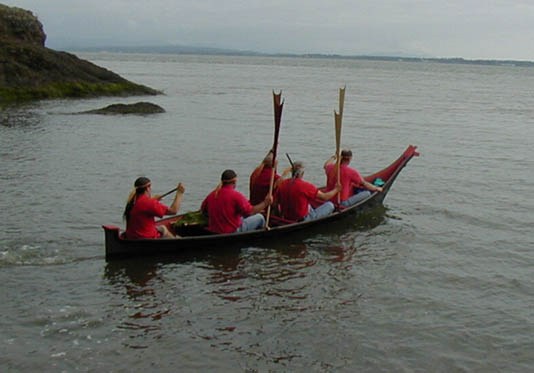 A photo of a taped-seam plywood replica of a Chinook dugout canoe on the Columbia River.